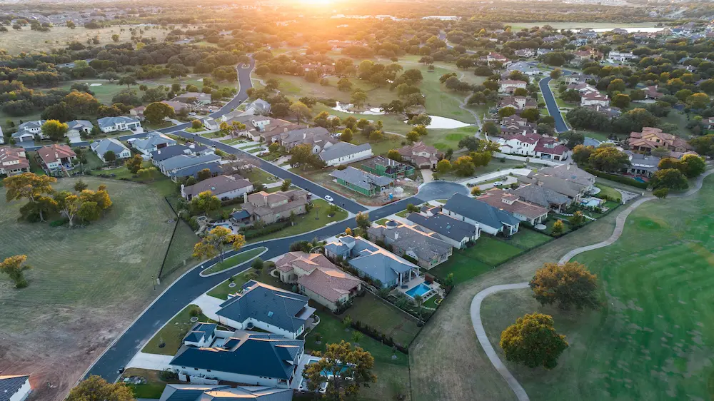 Aerial view of a beautiful Georgetown, TX neighborhood at sunset, showcasing homes DP Contracting serves.